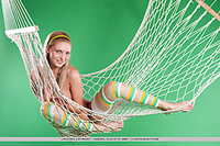 Lovable fun and sweet lapochka looks absolutely stunning in her bright striped stockings and yellow headband, posing playfully in a fishnet hammock.