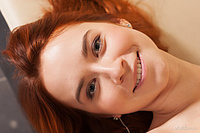 Pink on pink redhead kelly g bares her trimmed pussy as she poses on the couch.