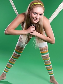 Lovable fun and sweet lapochka looks absolutely stunning in her bright striped stockings and yellow headband, posing playfully in a fishnet hammock.